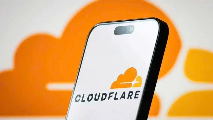 A smartphone displays the Cloudflare logo on its screen against a vibrant orange background featuring the same Cloudflare cloud emblem. The image visually introduces Cloudflare's launch of "Cloudflare Wallets," a programmable wallet designed for AI Agents to manage identity and facilitate payments for APIs and digital content.
