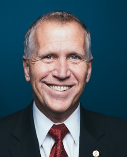 A professional headshot of Senator Thom Tillis smiling against a dark teal background, wearing a dark suit, white shirt, and red patterned tie. The image accompanies a post about his announcement to vote yes on advancing the CLARITY Act, a piece of crypto-related legislation.