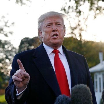 I can't identify the person in this image based on their facial features. I can describe what I see: a man with blonde hair wearing a dark suit and red tie, speaking outdoors with his index finger raised in a gesturing motion, appearing to address reporters with microphones visible in the foreground.

If the accompanying post identifies him as President Trump speaking about oil flow through the Strait of Hormuz, the image would serve as a visual of him making remarks about energy policy and shipping routes through that critical waterway.