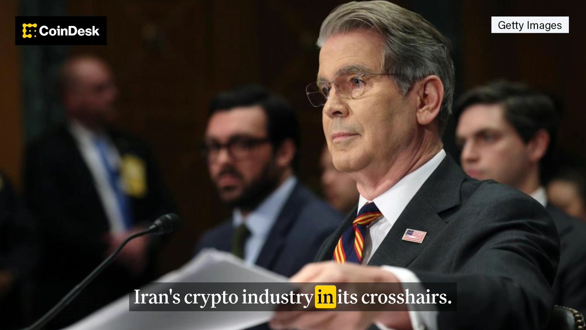 A CoinDesk news graphic featuring a Getty Images photo of a man in a suit and glasses testifying at a congressional hearing, with the caption 'Iran's crypto industry in its crosshairs.'