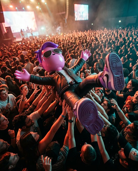 A purple cartoon character wearing sunglasses and a leather jacket being crowd-surfed over an audience at a concert.