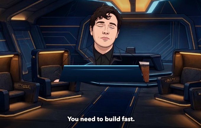 An animated figure with closed eyes and brown hair wearing a dark outfit sits inside a futuristic sci-fi cockpit, with the subtitle 'You need to build fast.'