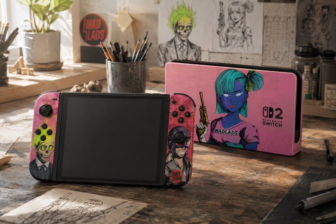 A Nintendo Switch console and case displayed on a wooden desk, featuring colorful artwork of zombie-like characters branded with 'MAD LADS' in pink tones.