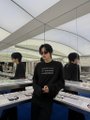 A blurry image showing a person in dark clothing in what appears to be an office or workspace setting.