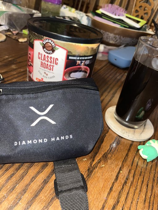 A morning scene featuring a Diamond Hands branded pouch alongside a container of Barnie's Coffee "Classic Roast" and a glass of dark coffee on a wooden table, perfectly capturing the "Good morning X" vibe with a nod to the iconic X (formerly Twitter) branding.