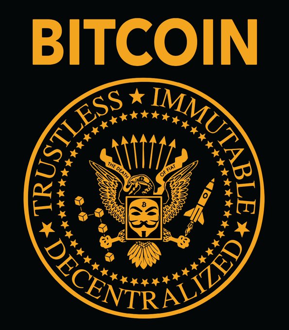 A circular emblem with a black background and gold/orange details reading 'BITCOIN', 'TRUSTLESS', 'IMMUTABLE', and 'DECENTRALIZED' around a central crest featuring an eagle, skull mask, arrows, rocket, and 'THE DEATH OF FIAT' banner.