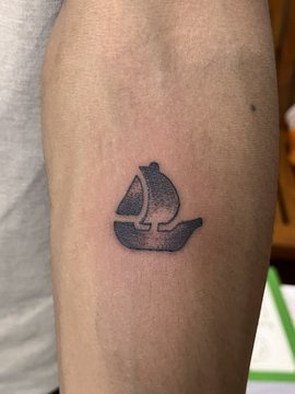 A freshly inked OpenSea sailboat logo tattoo on a person's forearm, made as a bold statement of brand loyalty to the NFT marketplace. The post humorously notes that even if they don't win a contest, they still walked away with permanent OpenSea branding.