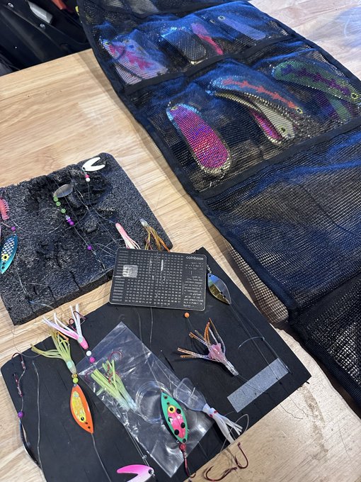 An assortment of colorful fishing lures and tackle are laid out on a dark surface, with the post creatively comparing the appeal of fishing bait to that of Bitcoin rewards, suggesting that while the fish aren't interested in crypto earnings, the company offers up to 4% back in Bitcoin on purchases as a real lure for customers.