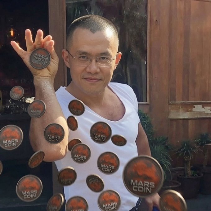 A man in a white tank top and glasses holding up a 'MARS COIN' token, with multiple additional Mars Coin tokens digitally scattered across the image.