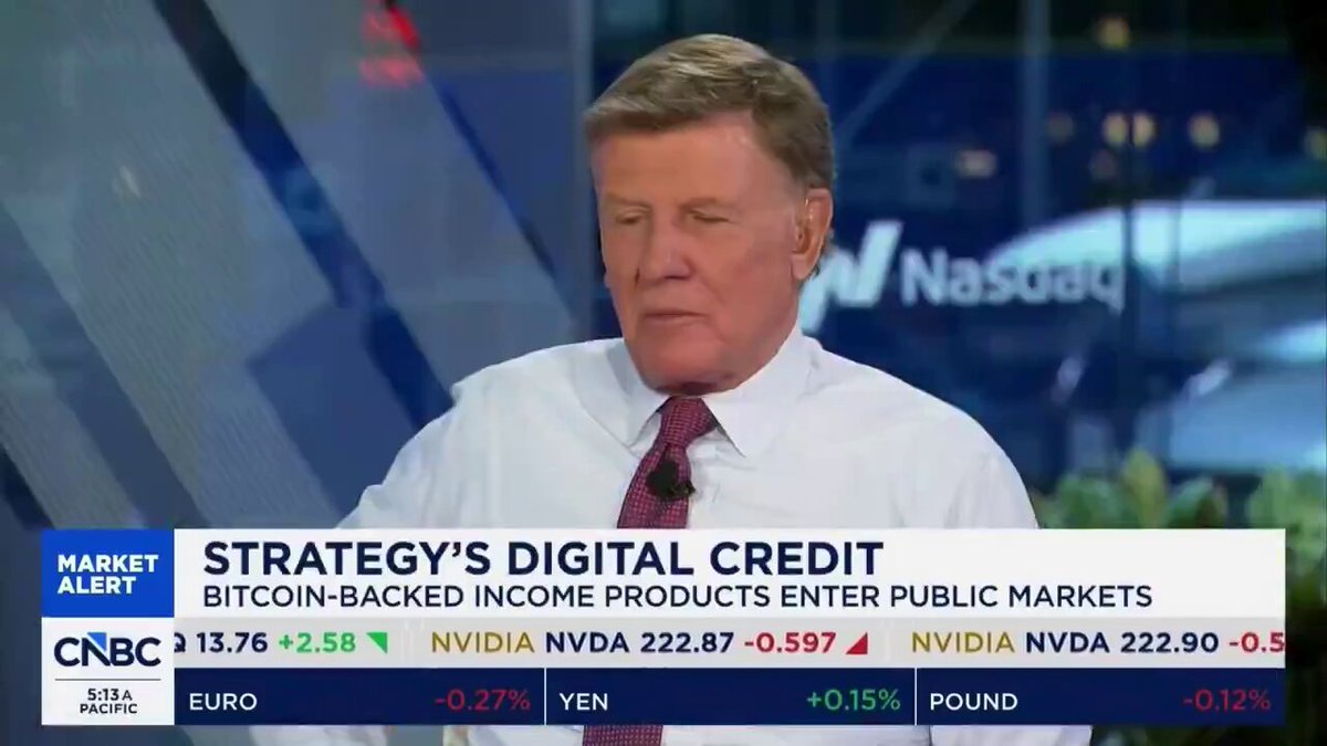 The image shows a man wearing a white shirt sitting at a desk with a computer screen behind him. The text displayed on the screen reads "MICHAEL SAYLOR SAID LIVE ON CNBC THAT STRATEGY TO BUY ALL 1,000,000 BITCOIN LEFT TO BE MINED." This quote suggests that the man is discussing a strategy to invest in Bitcoin and potentially buy 2,000,000 Bitcoins. The image also includes other text related to digital credit and market trends, which may provide context for the discussion of Bitcoin as an investment opportunity.