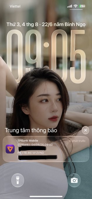 An iPhone lock screen displays "09:05" on Tuesday, June 22 with a portrait wallpaper of a young woman; a notification from TPBank Mobile shows a transaction alert with amount "+18.467.812VND".