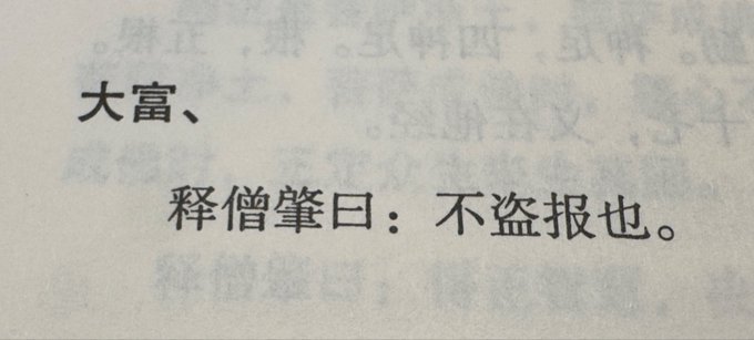 A close-up of Chinese characters printed on paper, with the prominent text reading '大富' and '释僧肇曰：不盗报也'.