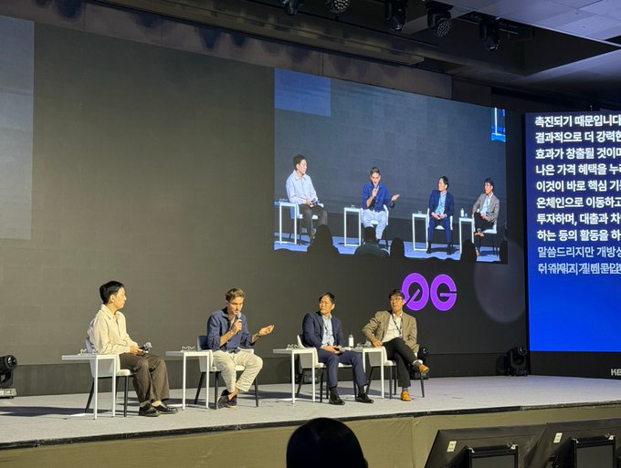 Five men sit on white stools on stage during a panel discussion at Korea Blockchain Week, with a large screen behind them displaying the same panel alongside Korean text and the "KBW" (Korea Blockchain Week) logo. The man second from the left holds a microphone, appearing to address the audience, consistent with Morpho CEO Paul Frambot speaking about institutional onchain adoption.