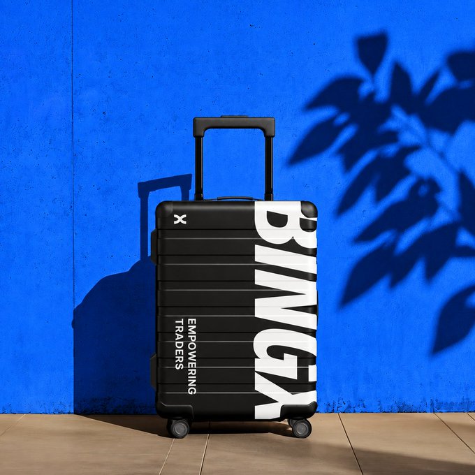 A black rolling suitcase with bold "BLVCK" branding and the tagline "EMPOWERING TRADERS" sits against a vibrant blue wall, casting a shadow beside leafy plant silhouettes—perfectly capturing the "roll, not carry" spirit of the caption.