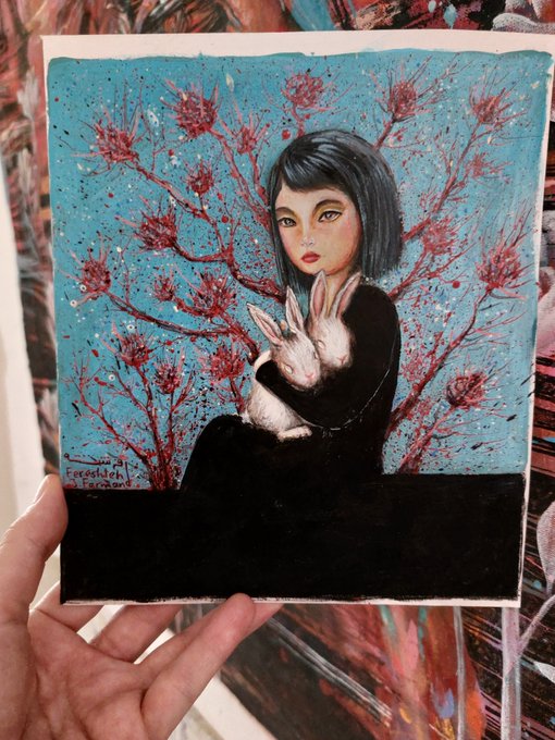 A hand holds a painting depicting a dark-haired girl in black clothing holding a white rabbit, set against a turquoise background with red blossoming branches, signed 'Eredelchen Lee Conway.'