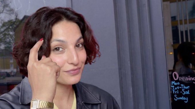 A woman with short, wavy auburn hair holds up her middle finger to the camera with a subtle smirk, wearing a black leather jacket and a gold watch. The connection to the post's message about "protecting your freedom" and not noticing "before it's too late" is visually reinforced by the rebellious, defiant gesture—symbolizing resistance or warning against losing personal autonomy.