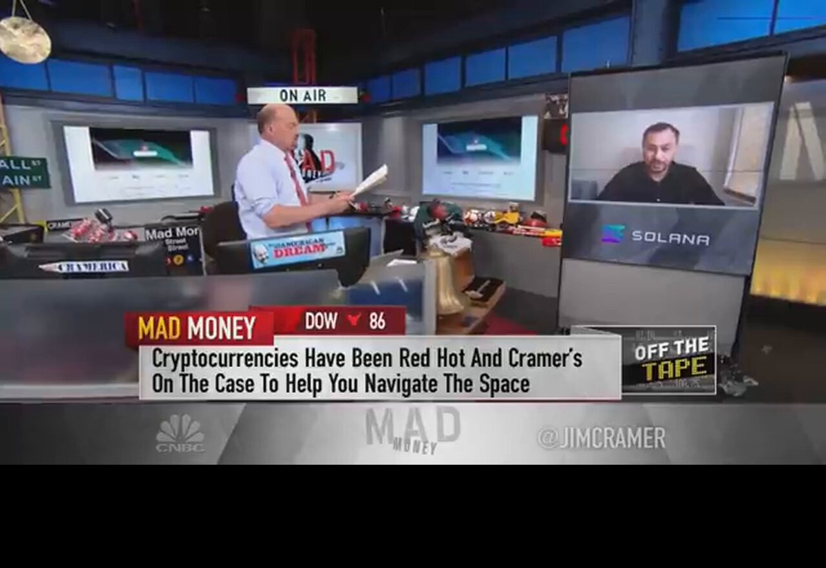 In the image, a man wearing a white shirt is standing behind a desk with two TVs displaying news about cryptocurrencies like Bitcoin. One TV shows a man talking about Bitcoin, while the other displays an advertisement for Solana. The text on the screens reads "The sun is rising on @Solana". This suggests that the post might be related to cryptocurrency news or events happening in the world of digital currency.

The image also includes a caption below the TVs, which reads "Focus on what is in the image and how it relates to the post". The caption provides context about the content displayed on the TVs and helps viewers understand the connection between the news and the post's title.