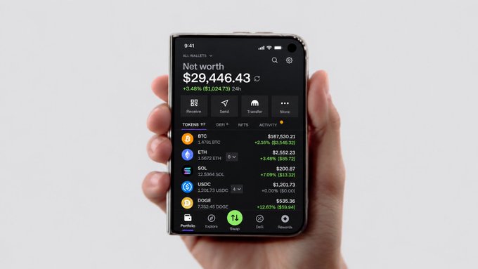 A hand holds a foldable iPhone Duo displaying the Kraken Wallet app, showing a net worth of $29,446.43 with holdings across BTC ($167,630.21), ETH ($2,552.23), SOL ($200.87), USDC ($1,201.73), and DOGE ($536.36). The image illustrates how the Kraken Wallet's multi-token tracking interface would appear on the dual-screen foldable device.