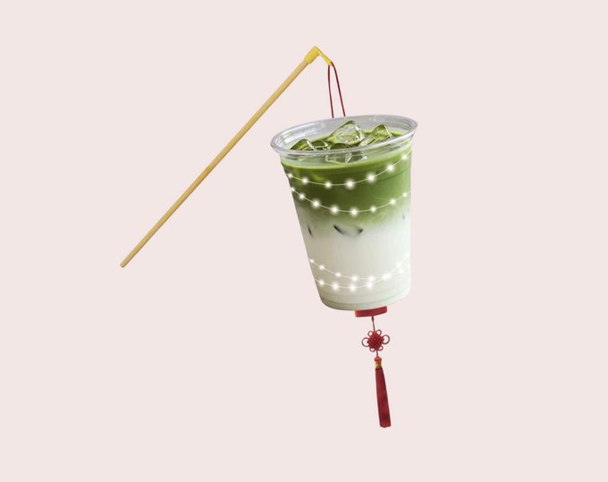 A creative image of a plastic cup of iced green tea/milk drink decorated to resemble a Chinese lantern, with fairy lights inside and a red tassel hanging from the bottom.