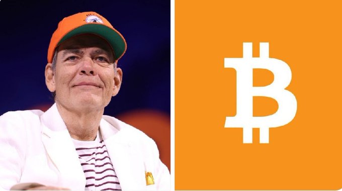 A man wearing an orange cap and white jacket is shown on the left, alongside a large Bitcoin (₿) logo on an orange background on the right, illustrating Max Keiser's bold prediction that the U.S. debt crisis could propel Bitcoin above $2,000,000.