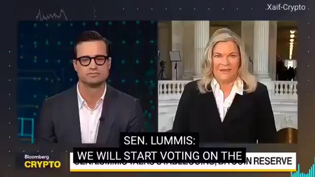 The image shows a news broadcast featuring two people talking about the CLARITY Act of 2006. The text "The CLARITY ACT is done, confirmed by Senator Lummis. The CLARITY Act just cleared another major hurdle, and the crypto industry is watching closely." is displayed on the screen along with the names of the individuals involved in the conversation. The image also includes a caption that reads: "If this momentum continues, 2026 could be remembered as the year everything changed".