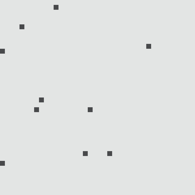 A simple white image with scattered small dark gray squares on a light background.