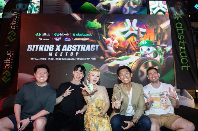 The image features a group of five people posing for a photo together at an event called Bitkub x Abstract meet up. The attendees are standing around each other, with one person holding a cupcake while another has their hand raised in a peace sign. They appear to be enjoying themselves and engaging in conversation about the event or the future of Web3 on Abstract.