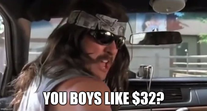 A man with long hair, sunglasses, and a bandana sits in a car, smiling and turning toward the camera with the caption "YOU BOYS LIKE $32?" — referencing the meme's association with $GME, likely alluding to the stock's price or a humorous take on trading gains.