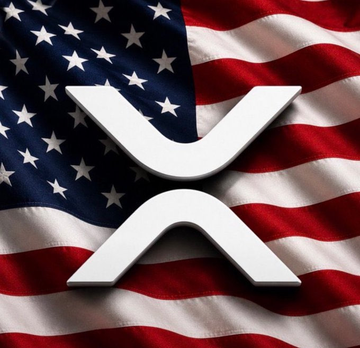 The image features the white XRP logo prominently displayed against the backdrop of a waving American flag. This visual ties to the post's discussion about Jake Claver's bold prediction that $XRP will reach $2,000 by the end of 2026, evoking a sense of patriotic optimism surrounding the cryptocurrency's potential price milestone.
