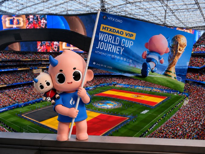A 3D-rendered mascot character with blue horns holding a flag that reads 'HTX DAO HTXDAO VIP WORLD CUP JOURNEY HTXDAO VIP世界杯尊享之旅 July 8-13, 2026' in a crowded soccer stadium with a large Spanish flag on the field.