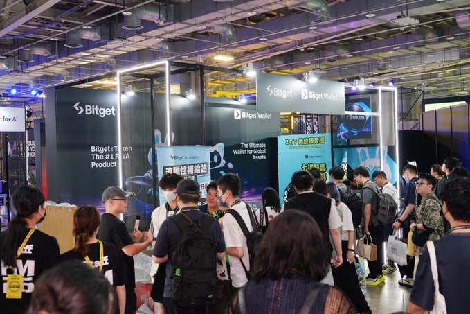 At the bustling Bitget Wallet booth during Day 1 of FUTUREMODE 2026, a large crowd of attendees wearing masks queues up around the "blue booth," eagerly waiting to receive promotional giveaways while the team focuses on crowd control rather than discussing their product offerings.