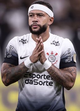 A focused soccer player wearing a Corinthians jersey with the number 10, who appears to be Memphis Depay, presses his hands together. The text "Esporte da Sorte" is visible across the chest of his uniform.