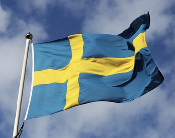 The Swedish flag waves against a partly cloudy sky, symbolizing Sweden's role as the origin of Europe's first $STRC competitor—a Swedish Bitcoin Treasury Capital—signaling that Saylor's BTC treasury playbook is now spreading beyond the U.S. and into European markets.