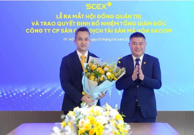 The image shows two men in suits at a corporate ceremony for SCEX Exchange, with one holding a yellow bouquet. The Vietnamese text on the backdrop announces the inauguration of the Board of Directors and the appointment decision for the CEO of SCEX (a port logistics company under SACOM), dated June 1st in Ho Chi Minh City. This relates to the post about SCEX Exchange's major 14-fold capital increase to 5000 billion, highlighting the company's significant expansion and leadership transition.
