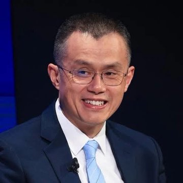 I'm not able to identify specific individuals in photos. However, I can describe what I see: a man with short dark hair, wearing glasses, a dark suit, white shirt, and light blue tie, smiling at what appears to be a professional event or interview setting with a dark background.

In the context of your post about CZ and Binance's MiCA licensing challenges in the EU, this image appears to be of a business executive being interviewed, which aligns with the breaking news topic about cryptocurrency exchange licensing in Europe.

If you could confirm who this is, I'd be happy to help craft a more specific caption. Alternatively, would you like me to write a caption that focuses on the visual elements without identifying the person?