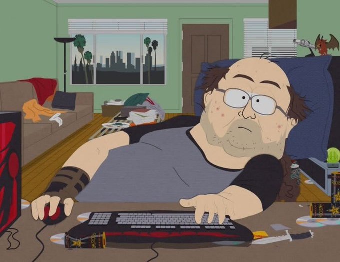 A South Park-style cartoon image of an overweight, balding man with stubble and glasses slumped at a messy desk using a keyboard and mouse, with a cluttered living room behind him featuring a city skyline view, scattered items, and a bat-like creature.