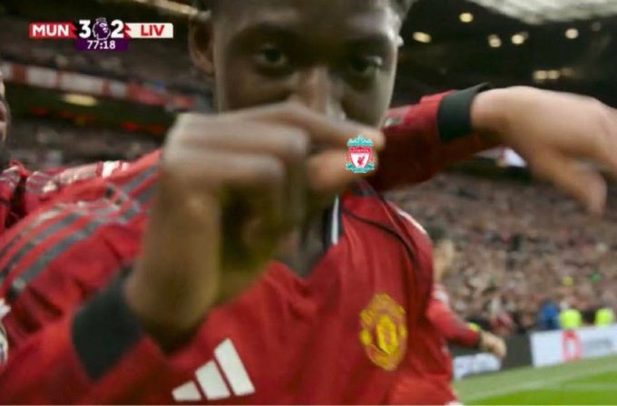 A Manchester United player in a red jersey celebrating a goal, with the scoreboard showing 'MUN 3 - 2 LIV' at 77:18 during a match.