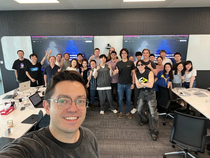 The EasyA development team gathers for a selfie at OKX's Kai Tak offices following their collaboration to build sample products for OKX's new AI marketplace. Visible text on the screens behind the group references the partnership between OKX and Web3.

The image shows the EasyA developers posing together in what appears to be a modern conference room at OKX's offices, visually confirming the team visit mentioned in the post about developing AI marketplace products.