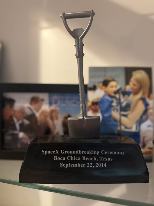A silver shovel mounted on a black marble base with the inscription 'SpaceX Groundbreaking Ceremony, Boca Chica Beach, Texas, September 22, 2014.'