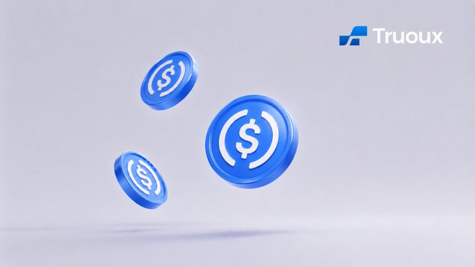 The image shows three blue USDC cryptocurrency coins floating against a light background, with the "Truoux" logo displayed in the upper right corner. The coins represent the stablecoin USDC, which directly relates to the article about Standard Chartered Bank expanding USDC services and Truoux exchange's focus on compliance and security in the digital asset space.
