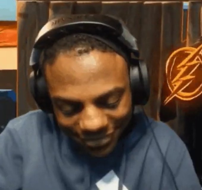 A man wearing headphones and a blue shirt looks down with an exasperated expression, with the "Flash" TV show logo visible in the background. The image humorously conveys the post's message about people being annoyed and not in the right state of mind first thing in the morning to engage online.