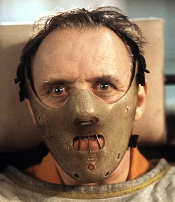 A scene featuring Anthony Hopkins as Hannibal Lecter wearing his iconic muzzle restraint mask from the film The Silence of the Lambs.