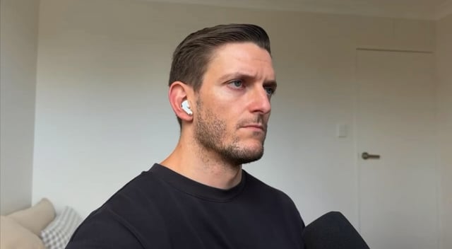 The image features a man wearing a black shirt, sitting down with his head tilted back while looking at something off-camera. There are two white earbuds visible near his ears, suggesting that he might be listening to music or a podcast. The caption "SAYLOR SOLD BITCOIN!!!" is written in the bottom right corner of the image, which could potentially be related to the post about the man's experience with the earbuds.