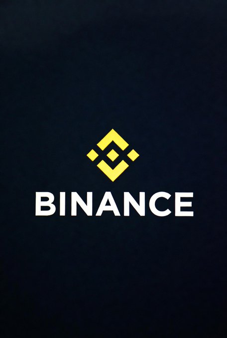 The image displays the yellow Binance logo and "BINANCE" wordmark on a dark background, visually representing the cryptocurrency exchange mentioned in the post announcing the completion of its NFT service migration to Binance Wallet.