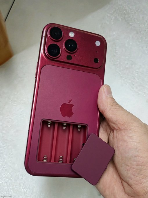 A hand holds a red iPhone featuring an open compartment containing three small springs, with a matching red square cover piece being held beside it.