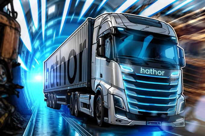 The image features a large white truck with blue accents, driving through a tunnel under a bridge at night. The truck appears to be a model of a Freightliner GVWH truck, which is known for its ability to apply transactions on the protocol level. This type of technology allows for secure and transparent interactions between digital assets, such as stablecoins or tokenized real-world assets, within a network infrastructure like the one depicted in the image. The truck's design emphasizes its role in facilitating these types of operations by showcasing aspects of its functionalities through its appearance on the street scene.