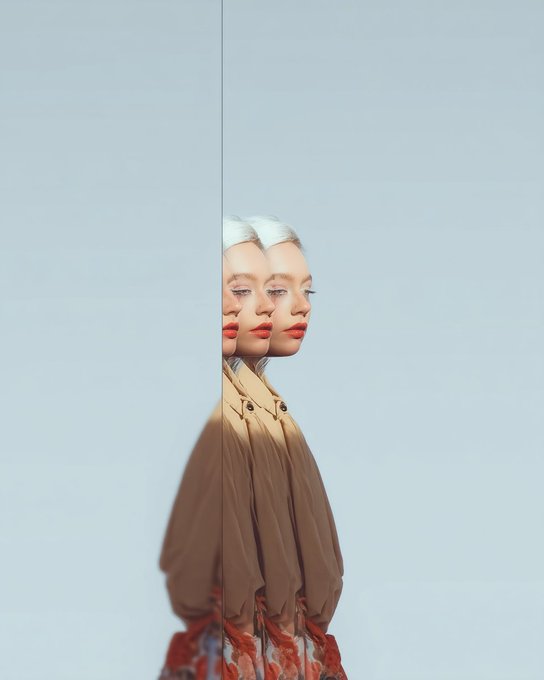 An artistic portrait photograph of a woman with platinum blonde hair against a light blue background, featuring a creative mirror/reflection effect that doubles her profile image.