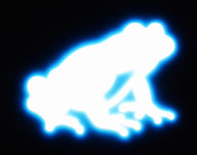 A glowing blue and white silhouette of a frog in a crouching position against a black background.
