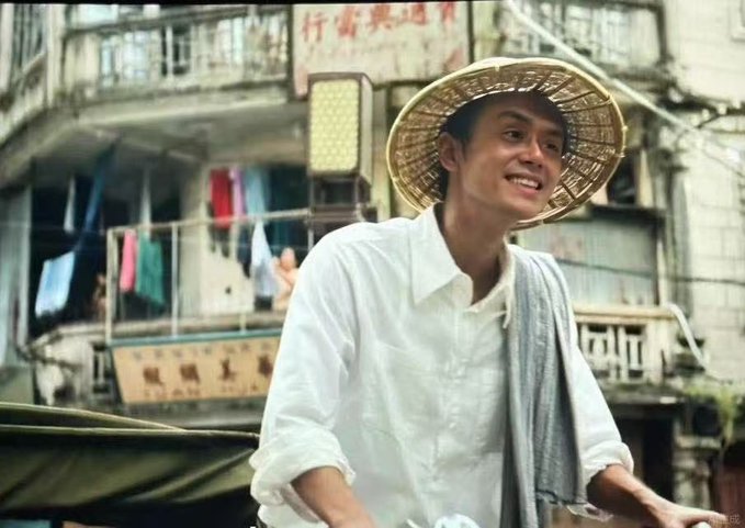 The image features an Asian man wearing a straw hat while sitting on a bicycle with his arm outstretched. The background shows a city street scene with buildings and clothes hanging from lines. There are also some Chinese characters visible, which could be related to the book "Binance Life".
