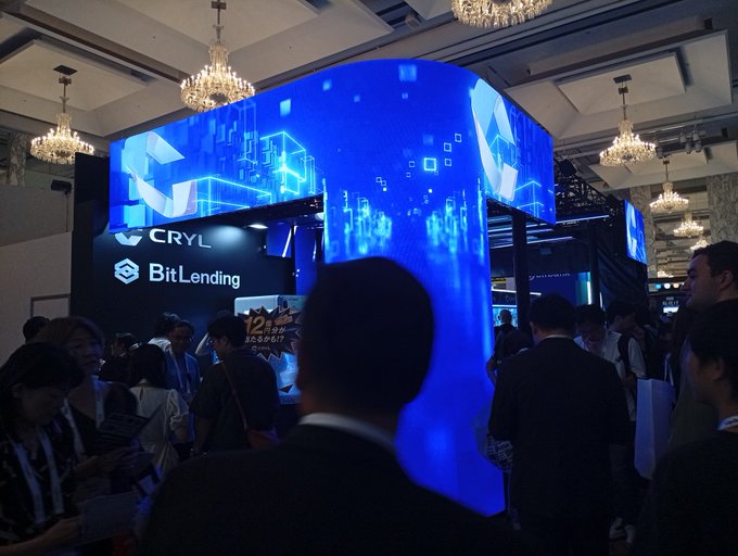 Attendees gather around the BitLending booth at WebX2026, where a large illuminated blue display showcases "CRYL" and "BitLending" logos, reflecting the bustling crypto conference atmosphere that the poster describes.